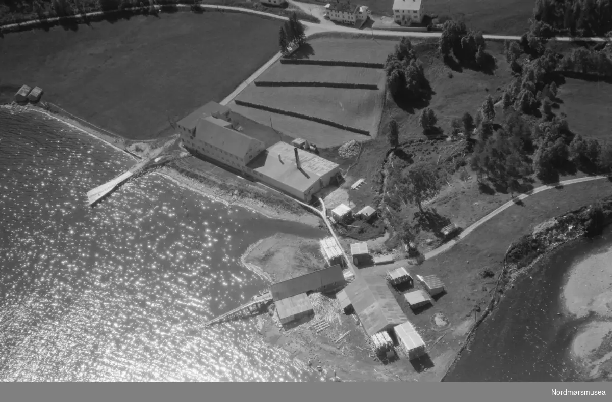 Bygningane til Angvik møbelfabrikk. Tønnefabrikken låg på andre sida av elveosen vi ser i høgre bildekant.
(Info: Lars Brubæk). Flyfoto. Fra Nordmøre Museums samlinger.