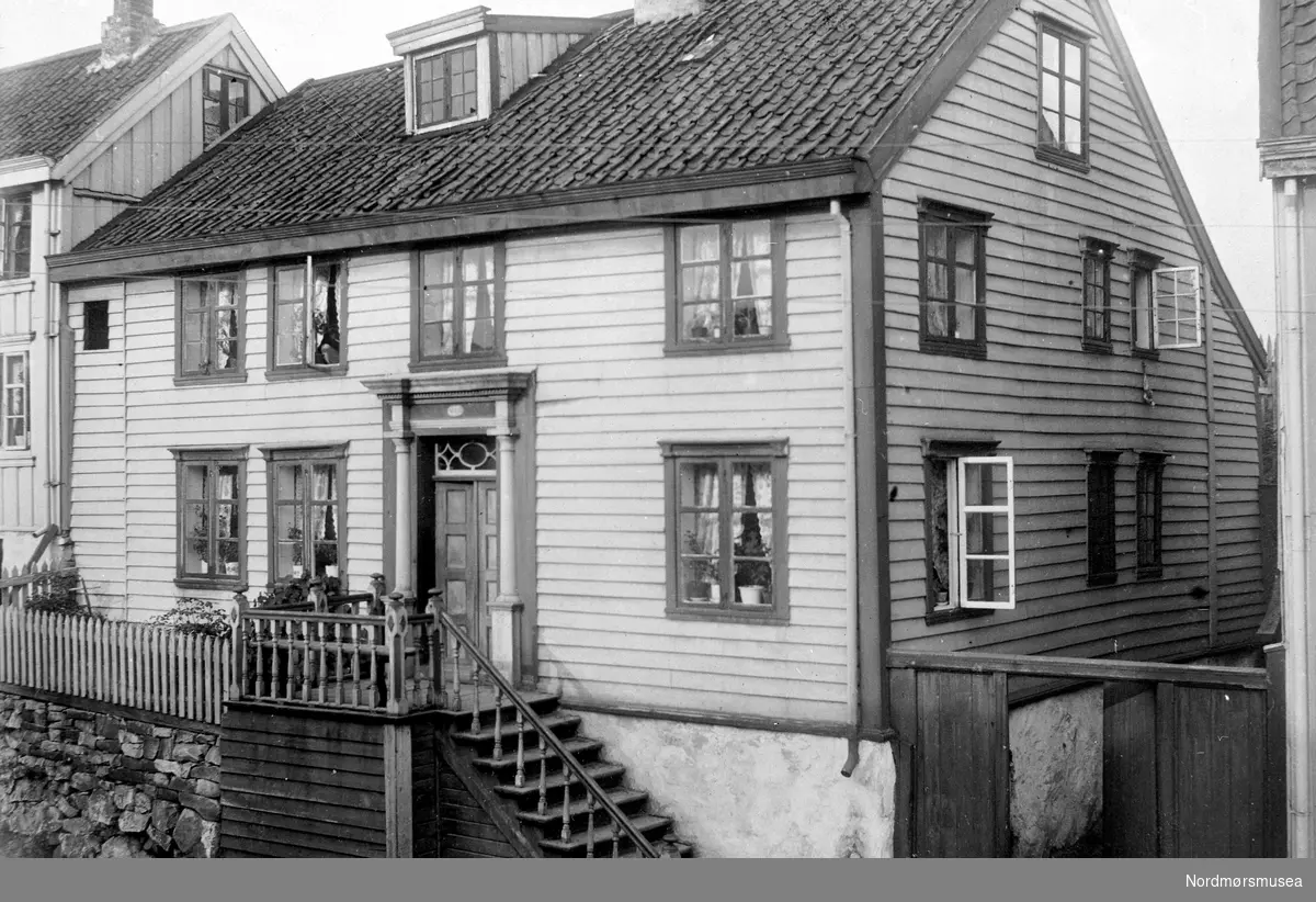 Baker Jorfalds hus i Hollendergata 4-5, matrikkel nr 12, foto 1908.
Hoveddøra har lengderifler i fyllingene, som er påfestet, ikke innfelt.  Husdørene var allerede utrangert og overtatt av museet.  Eieren av huset sier at W. Christie i sin tid fortalte ham at hans bestefar, kanselliråd Christie, bygde huset.  Merk margarin-reklamen. -- Lund-samlingen, 
";Bolighus i Storgata med matrikkel nummer 452."; Bildet er datert til 1909. Fra Nordmøre museums fotosamlinger.