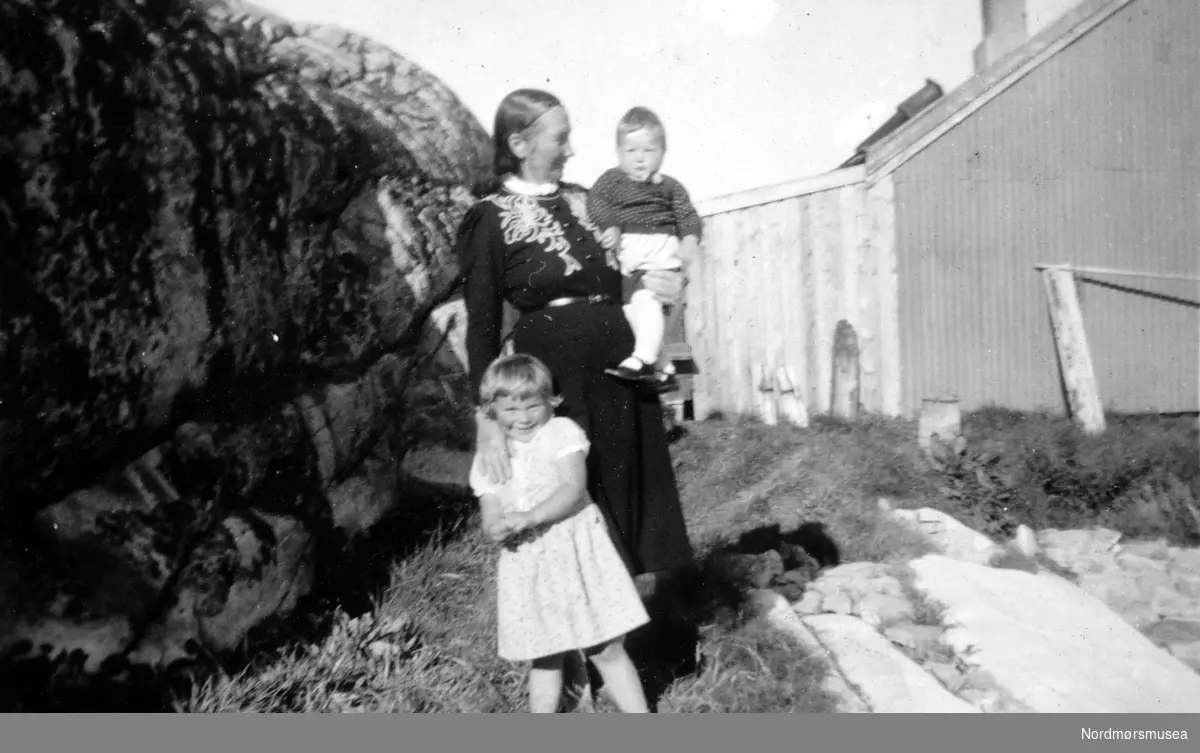 Foto av
en kvinne sammen med to små barn. Det er ukjent hvem vi ser på bildet, samt hvor og når bildet er tatt.
Trolig er det fra Kristiansund.
Bildet ble gitt til Nordmøre museum av Marit
Hestvik/Nelly Rødsand (Skjervaveien) 5. september 1983, og kommer fra albumet Erindring 4-10-1906. Fra Nordmøre museums fotosamlinger.
