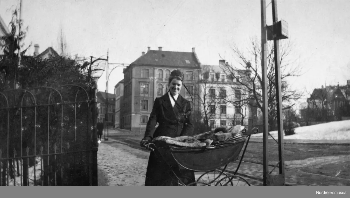 Portrett av en kvinne med barnevogn. Bildet er trolig tatt omkring 1918 til 1919. Bildet ble gitt til Nordmøre museum av Nelly Rødsand 5. september 1983. Fotoalbumet består av bilder med reg. nr. KMb-1983-024.0049 til KMb-1983-024.0223. Flere bilder fra andre album er å finne på samlingsnummer KMb-1983-024. Fra Nordmøre museums fotosamlinger. /Reg:EFR2013/



