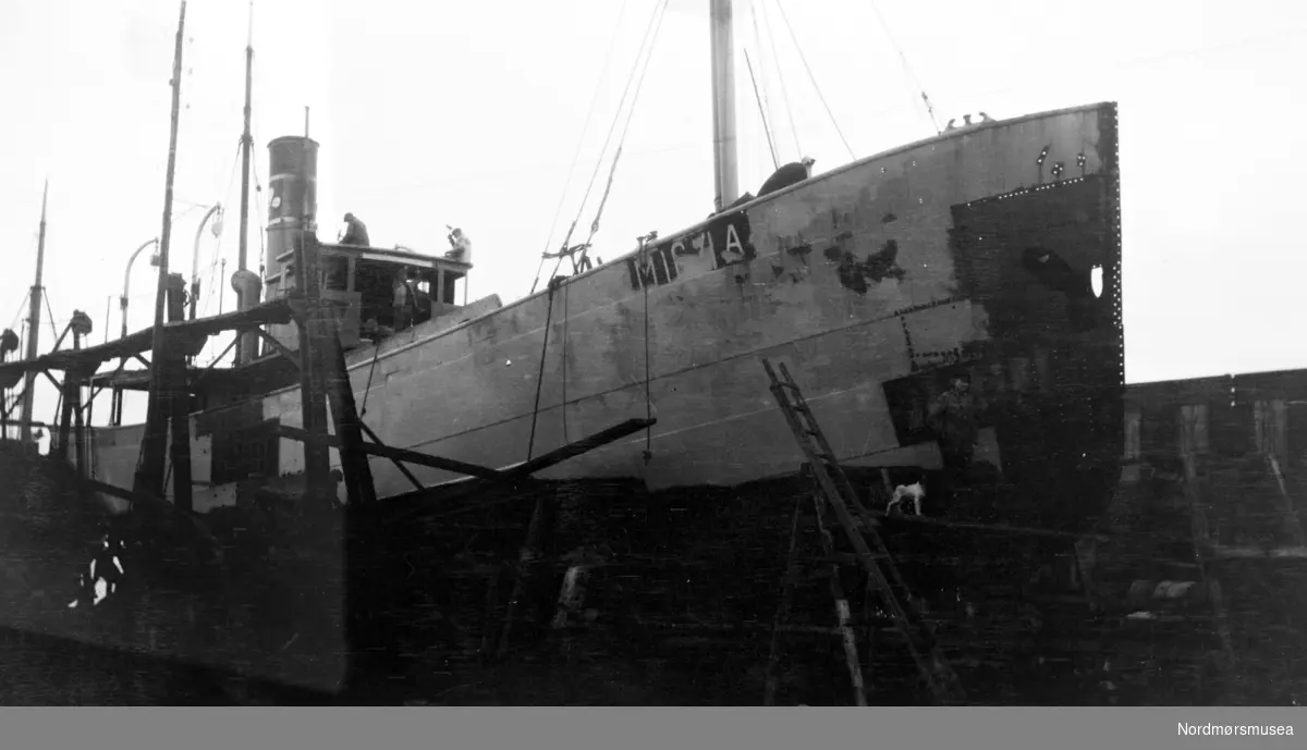 Bildet viser D/S”Utvær” på patentslippvogna ved Storviks Mek. Verksted på Dahle ved Kristiansund, klinkbygd i stål 1918, den største slippen mellom Bergen og Trondheim, for forlengelse i 1929.
D/S”Utvær” var bygget i 1914 ved Kristiansand Mek. Verksted for rederiet D/S Utværs Rederi A/S, Skjerva i Ålesund og hadde følgende hoveddimensjoner: L 105,4 fot x B 20,3 fot x D 10,3 fot og fiskeriregistrert med M-164-A.
Den ble overtatt av Ole Solbjørg, Ålesund i 1928 og beholdt samme skipsnavn.
Ole Solbjørg fikk den forlenget i 1929 ved Storviks Mek. Verksted og etter forlengelsen hadde skipet følgende hoveddimensjoner: L 117,4 fot x B 20,3 fot x D 10,3 fot og 187 BRT.
Til høyre ses litt av snekkerverkstedbygningen med slippspillet.
Personene på bildet er ukjente.
Bildet er fra 1929.  Info: Peter Storvik ---
Fartøy på slipp, trolig ved Storviks mekaniske verksted på Dale, Nordlandet i Kristiansund.
Datering og fotograf er heller ikke kjent. Fra Nordmøre museums fotosamlinger.