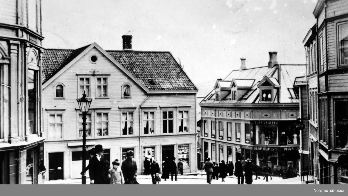 Midt i bildet ser vi Loennechen-gården, den eneste bygningen som unngikk flammene  i dette området under bombingen av Kristiansund i aprildagene 1940.  Til venstre for den går gaten ned til Piren ved havna.  Olaf Grimsmo har butikk til høyre.  Fotografen har stått ved Hvedinggården i begynnelsen av Hauggata.
(Fra Nordmøre Museums fotosamlinger)