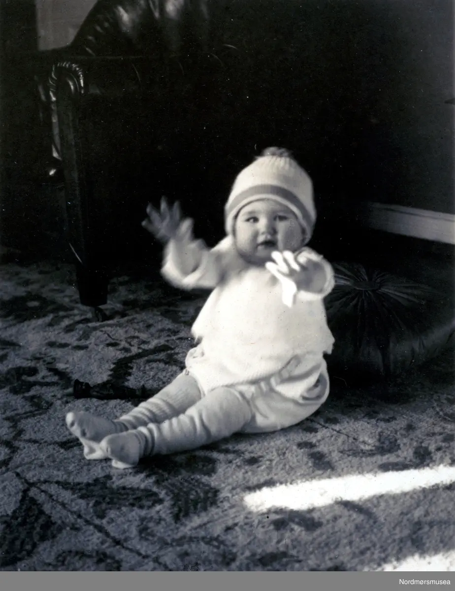 Foto av et baby sittende på gulvet trolig ved Fastingfamiliens bolig i Skolegata på Kirkelandet i Kristiansund. Fotograf er sannsynligvis noen fra den samme familien. Bildet er datert til 1923, og fotograf ser ut til å være en Christian Bøbak etter påført signatur. Fotoserie. Fotografier gitt til Nordmøre Museum fra Kate og Kristian Fastings arvinger per 1986. Fra Nordmøre Museums fotosamlinger. 
Bøbak var født i Lesja i Gudbrandsdalen 2. januar 1891. Læretida var først hos den anerkjente fotografen Hans H. Lie på Vinstra et par år fra 1909, seinere hos hoffotograf Karl Andersson i Kristiania (som hadde patent på retusjering). Han studerte samtidig tegning og maling, og var en dyktig treskjærer. Som ferdig utdannet hadde Bøbak et kort opphold på Dovre, før han etablerte seg i Kristiansund! (Hosar 2000). Fra 1919 deltok han på nasjonale og internasjonale utstillinger og oppnådde seks sølvmedaljer, tre bronsemedaljer og Landsforeningens gullmedalje. Han bestyrte Selmer Norlands fotoforretning i Bergen 1924-27, startet egen forretning 1928 i Storjohanns hus på Torvalmenningen 4 og var selv i firmaet til 1953. På det meste var det 18 ansatte. Nevøen Karsten Krogsæter overtok fra 1945, og avviklet 1974. En del av Bøbaks negativer ble da gitt til Universitetsbiblioteket i Bergen. I Bergen var Bøbak en drivkraft i musikklivet, og nær venn med Harmoniens dirigent Harald Heide. Han var oldermann i fotograflauget og stiftet kameraklubben i Bergen. Bøbak fikk tre sønner og to døtre. Sønnen Jan Magne fikk sine fiolinstudier i Paris og London bekostet av skipsreder Hilmar Reksten, og han ble konsertmester i Amsterdam-filharmonien. Chr. Bøbak regnes som en av de mest begavede portrettfotografer Norge har hatt. Kristian Hosar mener at han var - blant de ypperste i norsk og nordisk portrettkunst. Svenskekongen var blant Bøbaks store beundrere. Bøbak konstruerte et letthåndterlig kamera til barnefoto, som på grunn av andre verdenskrig aldri kom i produksjon. . - Chr. Bøbak var fiolinist, og Herman Fischer var cellist. Begge var medstiftere av Kristiansund Symfoniorkester i 1919. Og de ble styreledere, etter tur. Bøbak var gruppeleder på andrefiolin i orkestret, fram til han forlot byen i 1923. Det var også i Kristiansund han giftet seg i 1920, med den svenske pianisten Magda Gauffin. Dette var gode tider med høykonjunktur. Byen hadde fem private kinoer, og KSOs første konsertmester Oscar Ramstad var typisk nok profesjonell kinomusiker. Jeg gjetter på at Magda Bøbak også hadde en slik jobb. Andre spilte på restauranter og hoteller. Bøbak har noen påfallende likhetstrekk med Marcus Thrane. Begge var fiolinister og fotopionerer, og politisk aktive - men hver på sin ytterkant. 

