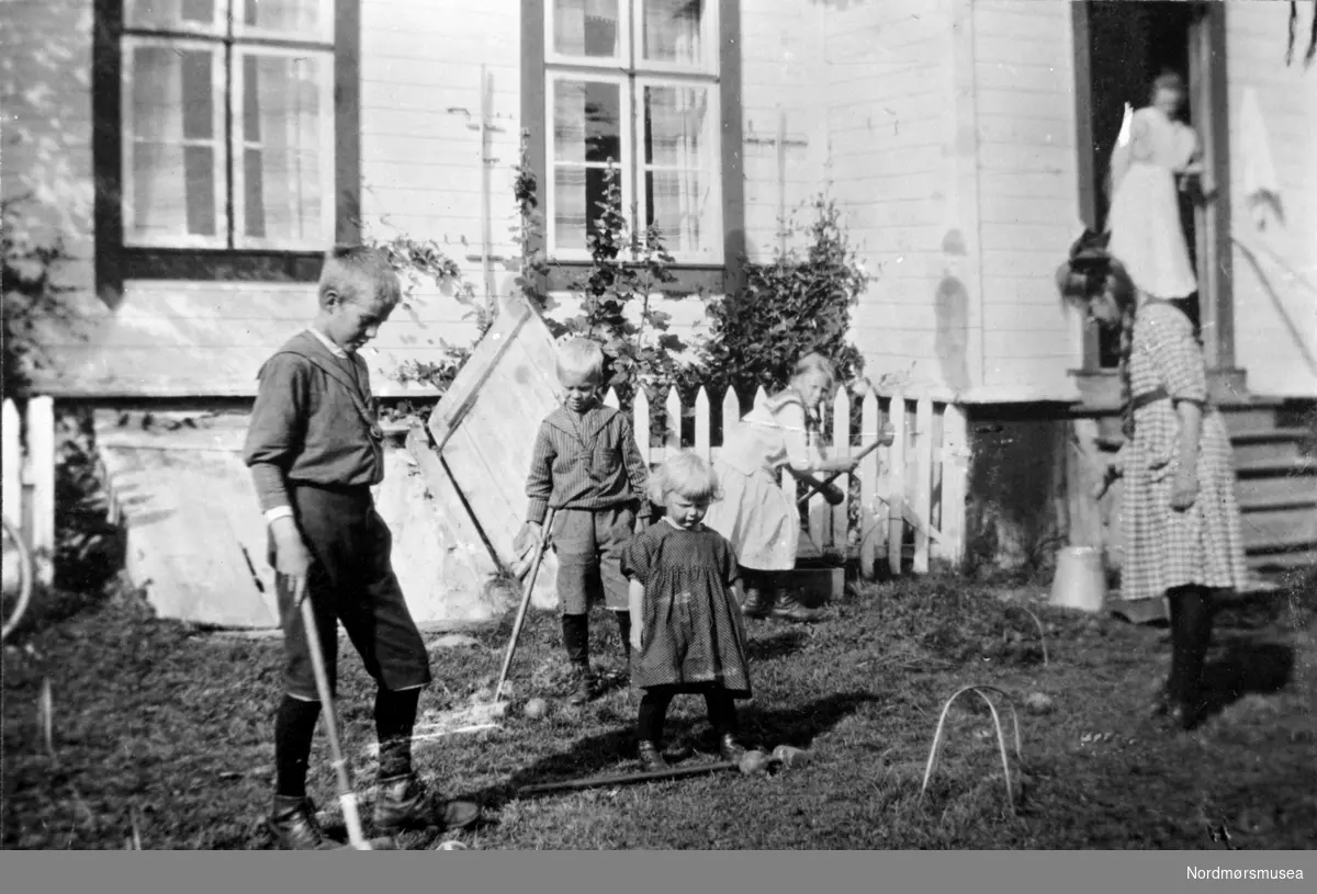 6 barn leker på en gard i Sunndal på 1940-tallet. Cricket. Ingeniørbarn? Fra Nordmøre Museum sin fotosamling.