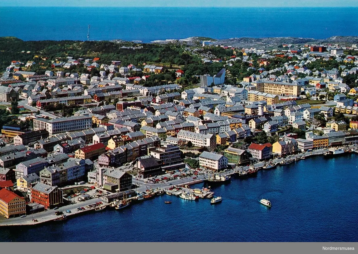 Postkort ";2568/19"; med flyfoto fra Kirkelandet i Kristiansund, med Piren sentralt i bildet, stikkende ut fra kaia midt på bildet. Kortet er utgitt av Mittet &amp; Co. A/S.
kirka,
 Allanengen skole, havnebasseng,

Kaia med to torg, før Amfi Storkaia Brygge. 
Nordmøre Museums fotosamlinger.
