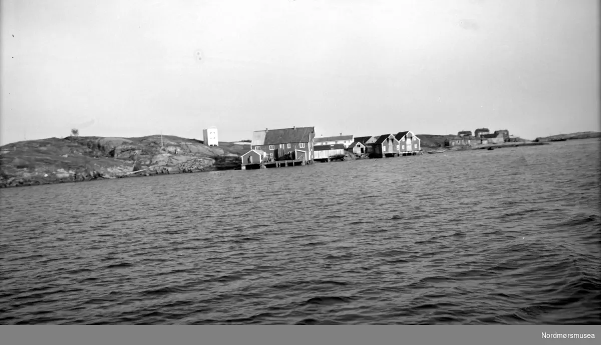 Foto fra Vevang i Hustadvika kommune. Vi ser  sjøhusene som ligger nede ved strandlinjen. Fra Nordmøre museums fotosamlinger. Reg: EFR