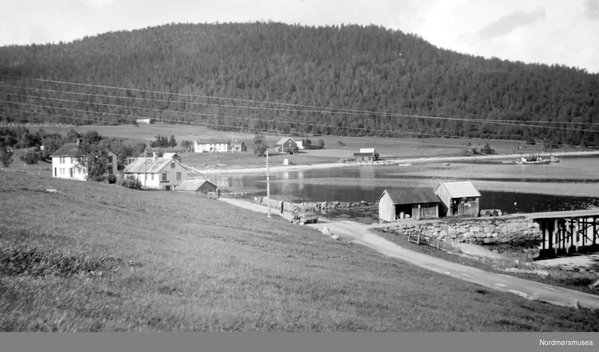 Dette bildet er fra Eidsøra i Nesset kommune. På vegen står fotografens bil, Ford A, 1930 modell. Skiltet på veggen til det nærmeste hvite huset, er reklame for tobakk. Martin Bugge hadde landhandel der. (info: Eyolf Sæbø)


 landskapsbilde  Fra Nordmøre Museum sin fotosamling.