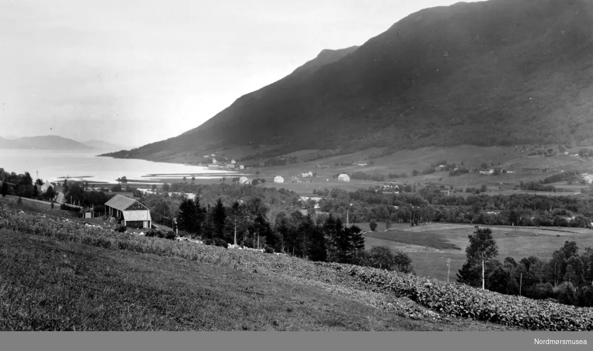 Parti fra Batnfjorden i Gjemnes kommune. Her med bygda ved strandlinjen. Fotograf er Georg Sverdrup, og datering er 1935. Fra Nordmøre Museums fotosamlinger. Reg: EFR
