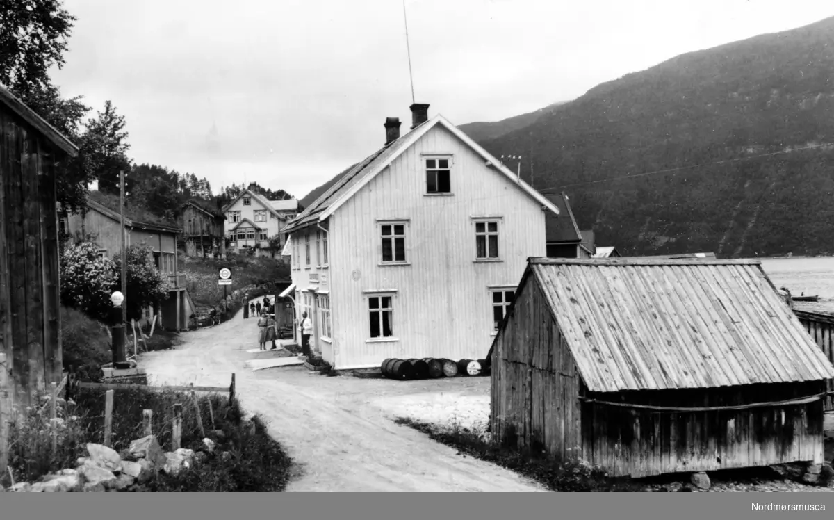 Landevei med bebyggelse i Todalsøra i Surnadal kommune, hvor vi ser fra bebyggelsen som går langs veien. Fotograf er trolig Georg Sverdrup, men datoen er 1939. Fra Nordmøre Museums fotosamlinger.
