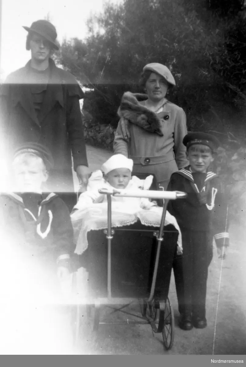 Familiebilde. Damen til høyre er Gudrun Margrethe Rød, født Maur. Barna på bildet er Gunnar, Per Olaf og Ivar Rød. Ukjent person til venstre i mørk jakke. Fotograf er sannsynligvis et medlem fra Rød familien. Ukjent datering, trolig mellom 1930 til 1939. Giver av bildet er Turid Rød. Fra Nordmøre Museums fotosamlinger. Reg: EFR
