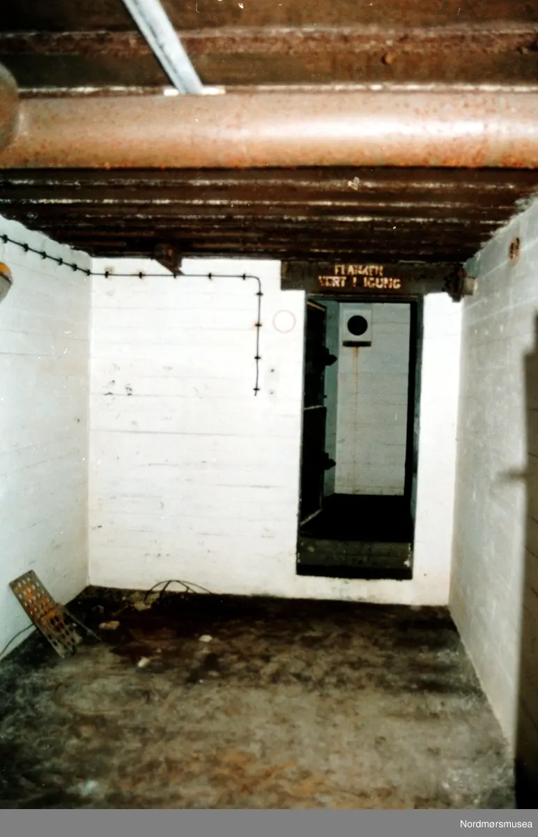 Foto fra kanonstilling i Hauggata 43 - 45 på Kirkelandet i Kristiansund. Bildet er datert 19. september 1991 og fotograf er Stein Magne Bach ved Nordmøre museum. betong, hvitmalt, velholdt. Se serie fra reg. nr. KMb-1991-039.0001 til KMb-1991-039.0017. Fra Nordmøre museums fotosamlinger.
