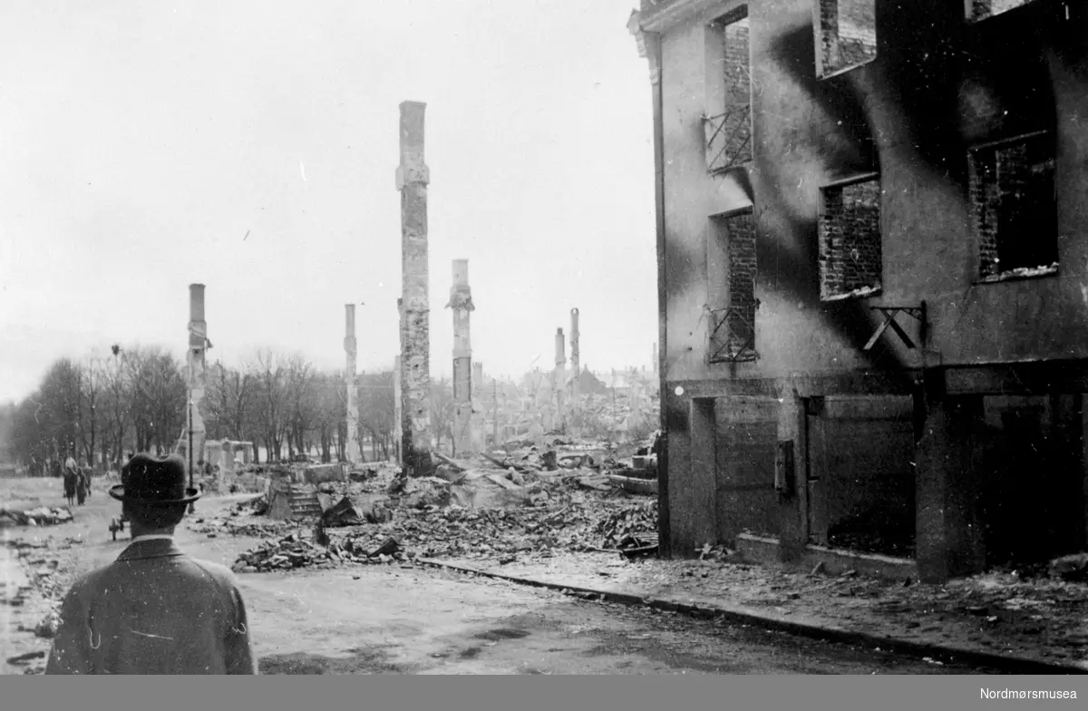 søndagstur med hatt i den bombede, brente byen

 Fra Nordmøre Museum sin fotosamling.
