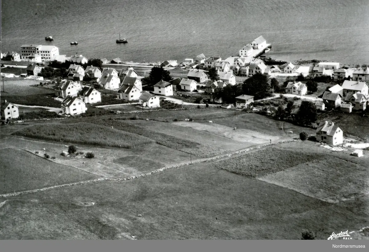 Postkort og flyfoto 9-t-7 ";Hareid"; som viser bygda i Hareid kommune. Fotograf/utgiver er K. Harstad fra Oslo.  Fra Nordmøre museums fotosamlinger. Reg: EFR
