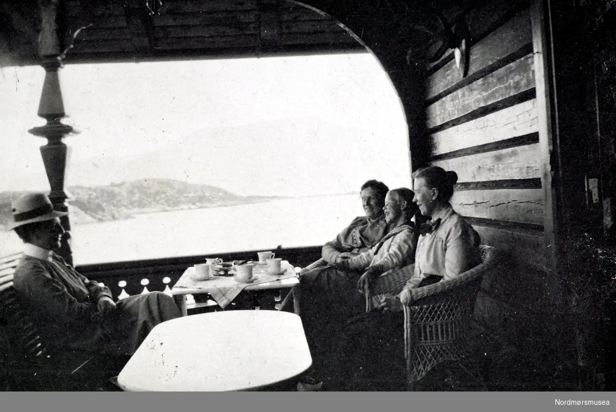 Foto fra familien Hvedings landsted på Fagernes, Frei, i Kristiansund kommune. Det er sannsynligvis familien Hveding vi ser ute på terassen. Fra Nordmøre museums fotosamlinger. Reg: EFR
