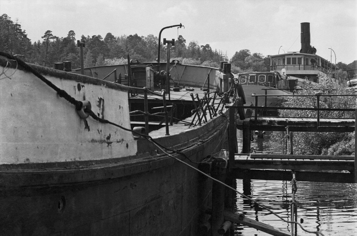 Fartyg i Mörtviken vid Ekensbergs varv 1970. I förgrunden varvspråmen, f d bogserbåten FLINTRÄNNAN, i bakgrunden skärgårdsbåten ÖSTANÅ I