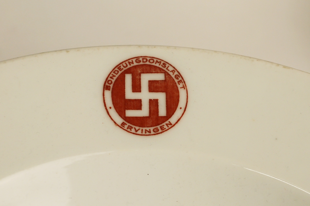 Serviset er sett saman av åtte delar, to tallerkenar , fire små djuptallerkenar, og to store djuptallerkenar. Tallerkenane er alle prega med logoen til Bondeungdomslaget, nemleg ein svastika, eller ein solkross. Seks av tallerkenane har raud farge i logoane, to har blå farge. Ifølgje Grepstad (2006:203) var den norrøne solkrossen "sjølvsagde symbol" for både kaffistova i Bergen og andre lagsbruk. Gløden for norrønt samkvem i samtid går også klart fram av jubileumsskriftet "Bondeungdomslaget Ervingen 1900-1950" (1950:141-147). Logoen er derimot ikkje omtala i det heile i dette skriftet.