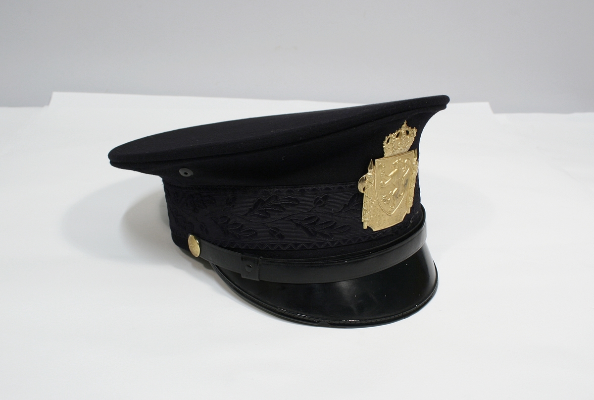 Sort jakke og bukse med blåskjær. Jakken er enkeltspent med seks forgylte knapper med riksløven. Stiv stående krage med broderte ekeløvblad, flettet sort skulderdistinksjon av sort innflettet gulltråd og en knapp. To brystlommer med klaff, ingen sidelommer. 

Kryssbandolær i brunt lær. Sort uniformslue med tresse og bratt skjerm i sort lakk og bredt luebånd med innvende eikeblader. Tressen er festet med to forgylte knapper. Gullforgylt luemerke.