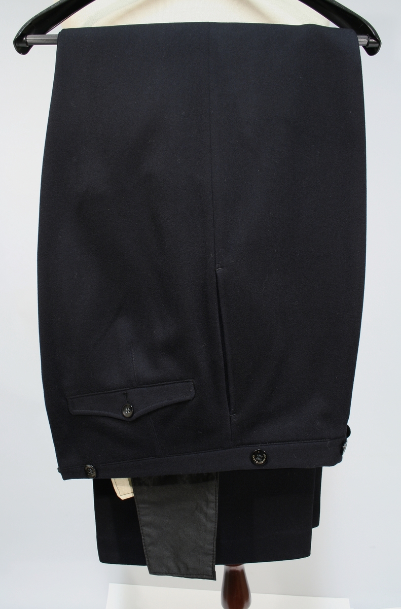 Sort jakke og bukse med blåskjær. Jakken er enkeltspent med seks forgylte knapper med riksløven. Stiv stående krage med broderte ekeløvblad, flettet sort skulderdistinksjon av sort innflettet gulltråd og en knapp. To brystlommer med klaff, ingen sidelommer. 

Kryssbandolær i brunt lær. Sort uniformslue med tresse og bratt skjerm i sort lakk og bredt luebånd med innvende eikeblader. Tressen er festet med to forgylte knapper. Gullforgylt luemerke.