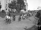 En amerikansk idrottstrupp cykelparaderar på väg till Tingvalla i slutet av 1930-talet.