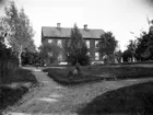 Almars gård på en bilden tagen runt förra sekelskiftet. Mannen i fönstret är kyrkoherde Fredrik Thorelius.