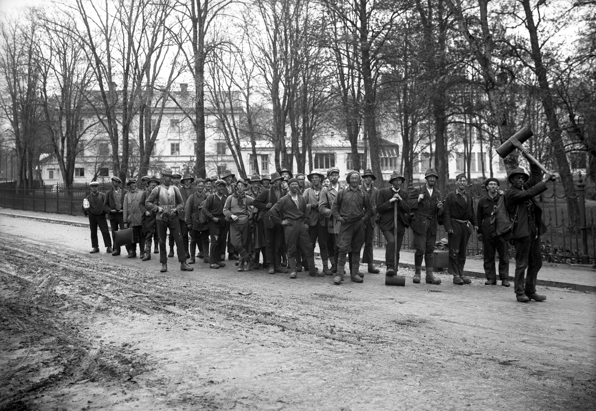 Grupp med elever från Gammalkroppa skogsskola i någon form av upptåg med koppling till kolmilning, en utbildning som gavs på skolan. Bilden togs på 1920-talet.