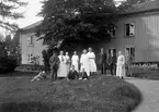 Grupp med människor framför större fastighet i Filipstadstrakten. Bilden är sannolikt tagen vid Stöpsjö herrgård.