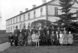 Äldre kvinnor och män samt en ung flicka och en präst fotogr