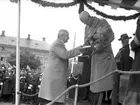 Bildsvit från Karlstads 350-års jubileum den 29 maj 1934. Stadsfullmäktiges ordförande Valdemar Vendel överlämnar stadens festskrift.