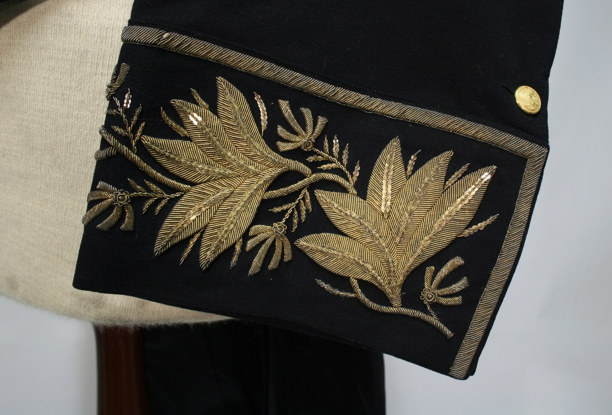 Gullbrokade på ermer og krave.