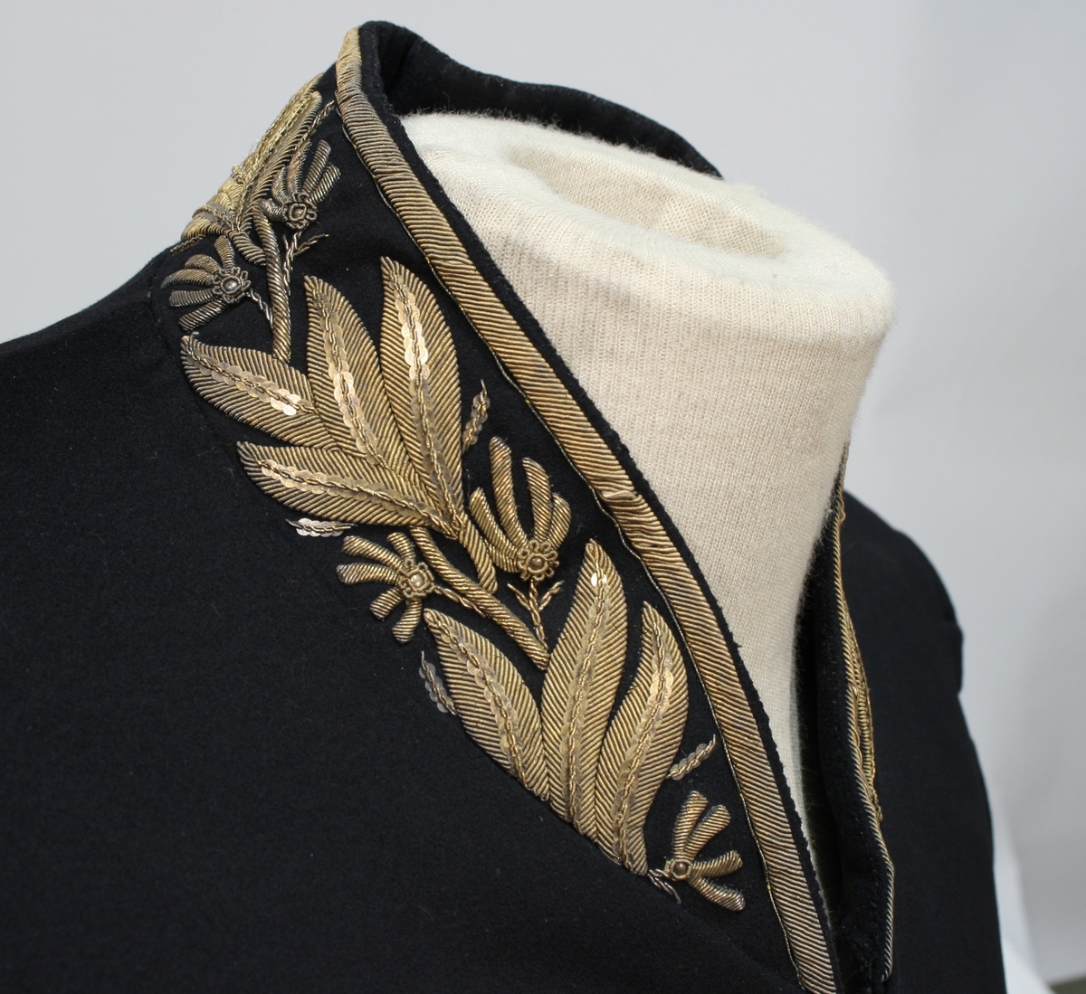 Gullbrokade på ermer og krave.