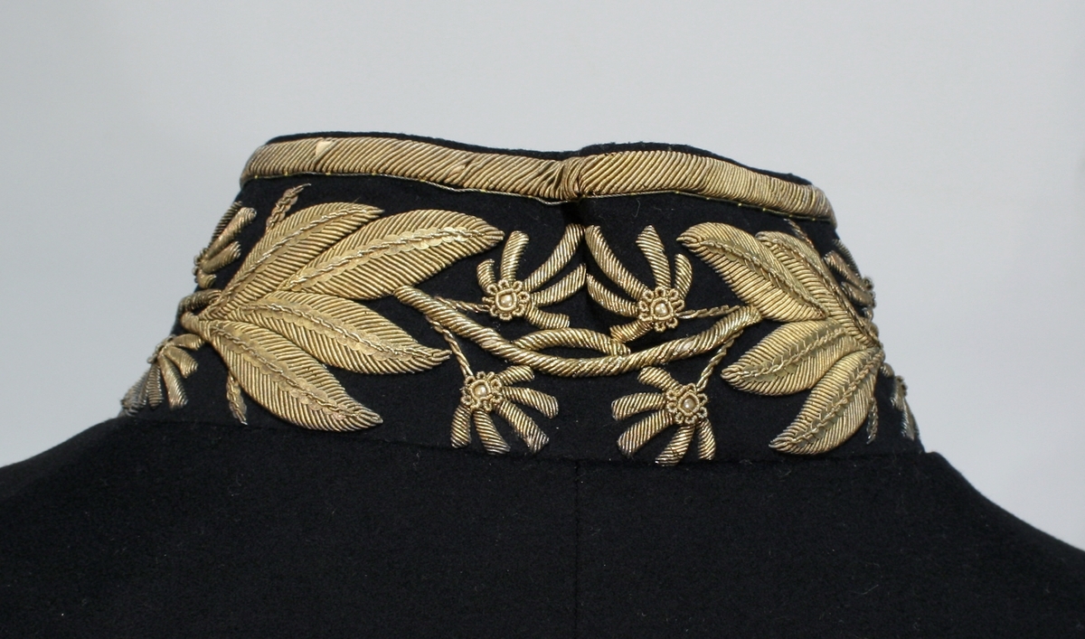 Gullbrokade på ermer og krave.