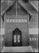 Biologiska museet entré. Arkitekt Agi Lindegren efter förbilder från de norska stavkyrkorna i Borgund, Lom och Urnes. Portalens träsniderier i relief ansluter nära till Borgunds stavkyrka I Sogn og Fjordane. Fotografi från omkring 1900.