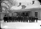 Häradsfältskjutning Köpings stad och Åkerbo skyttegille den 18  januari 1911. Skyttegillenas medlemmar fotograferade framför Gässlinge gård, Bro. 
Fotograf E Sörman.