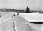 Snön ligger djup på ladugårdstaket hos 