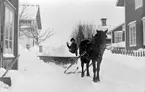 Jöns Wilander med häst en snörik vinterdag på Kvistholmsgatan i Norrsundet. Det vita huset till vänster bör vara Wilanders villa och huset längst bort till höger Brinkgården.