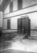 På trappan till huset. Tidsomfånget är 1900 - 1940