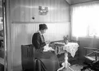Sitter och syr. Tidsomfånget är 1900 - 1940