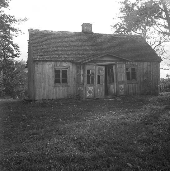 Ett förfallet bostadshus med glasveranda.