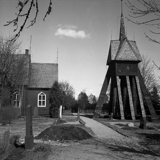 En träkyrka med klockstapel till höger. 
Tutaryd.