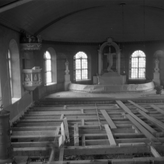 Kyrkointeriör med uppbrutet golv inför omläggning.
Ryssby kyrka. 1949.