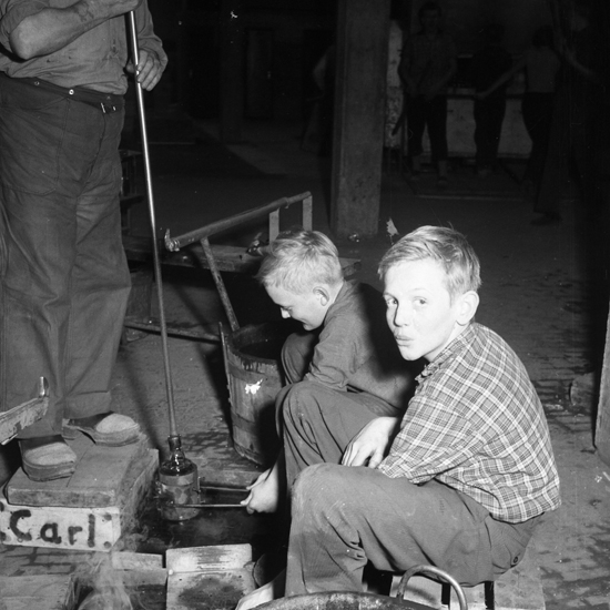 Lindshammars glasbruk. 1956. Två unga pojkar arbetar som formhållare.