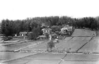 Vy mot Lötbacken i Skog. I första huset (röda) bodde länsman Müntzing, och i den vita gården bakom bodde länsman Fredrik Wibling.