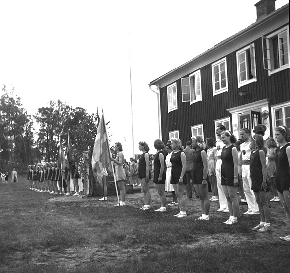 Foto på gymnaster på rad framför huset.