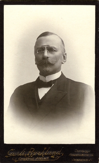 Porträtt (bröstbild, halvprofil) av en man med pincené, iklädd mörk kavaj, vit skjorta med stärkkrage och mörk fluga. 

Alfred Fornander (1855-1937), sparbanksdirektör, riksdagsman m.m., Växjö.
G.m. 1. Carin Fahlström (1852-1898), 2. Agnes Lekander (1865-1943).
Källa: Bl a gravsten, Tegnérkyrkogården, Växjö.