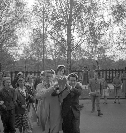 Studenterna tredje dagen, 1950.
En kvinnlig student bärs in av sina kamrater, någonstans i Växjö. 
Något suddigt foto.

Angående avgångsklasserna 1950 - se "Lärare och Studenter vid Växjö 
Högre Allmänna Läroverk 1850-1950" (1951), s. 193-196, 289.