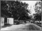 Häst och vagn, Hamrånge kyrka i bakgrunden. Den gamla kyrkogårdens mur till vänster. Reprobild.