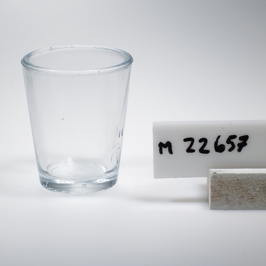 Mätglas.
Tillverkat på Sölvesborg, Sölvehyttan.
Beskrivning: Konoid. Bokstäver och siffror i relief. "-30, M-15, D-10, T-5".
Färg: Ofärgat klarglas.
Mått: Ovan angivna diameter avser glasets övre diameter. Bottendiameter: 33 mm.
Inskrivet i huvudkatalogen 1974.
Funktion: Mätglas