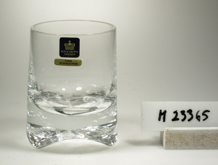 Tumlare. Tillverkat av Krona Bruken, Åseda glasbruk.
Formgivare: Bo Borgström.
Beskrivning: Konad, (smalnar uppåt) tjock botten med tre uddar.
Färg: Ofärgat klarglas.
Kristallglas?
Mått: Ovan angivna mått avser övre diameter.
Bottendiameter: 70 mm.
Fyrkantig, svart etikett med en krona och text i guld: Se "Signering, märkning" 1 ovan.
Avlång guldetikett med text: Se "Signering, märkning" 2 ovan.
Inskrivet i huvudkatalogen 1975.

Ur "Glas 75" utställningsglas.
Funktion: Tumlare