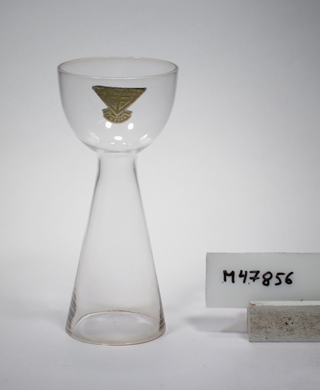 Äggkopp "A 571/3", formgiven av Lennart Andersson 1957 (uppgift från Gullaskuf-kännaren Raoul Karlsson 2020-01-21)
Koniskt ben/fot, som övergår i en rundad kupa.
Etikett i gult och guld. Se "Signering, märkning" ovan.
Inskrivet i huvudkatalogen tidigast 1991.

Kjell Blomberg (1931-), designer m.m.. Verksam vid Gullaskruf 1954-1977.
Funktion: Äggkopp