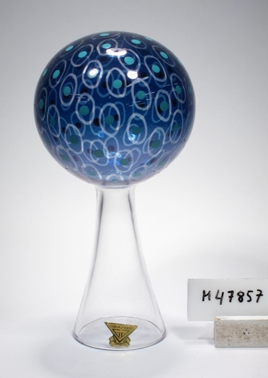 "Klothepp", glasskulptur formgiven av Kjell Blomberg. 
Koniskt ofärgat ben med ett blått dekorerat klot. På klotet dekor i form av vita, ovala och ljusblå prickar.
Märkning: Gul- och guldfärgad etikett med text "Gullaskruf Sweden".
Inskrivet i huvudkatalogen tidigast 1991.